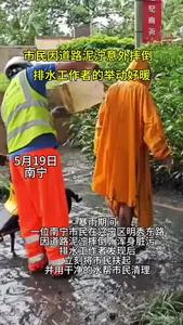 5月19日暴雨期間，一位南寧市民在興寧區(qū)明秀東路因道路泥濘摔倒，渾身臟污。排水工作者發(fā)現(xiàn)后，立刻將市民扶起，并用干凈的水幫市民清理。